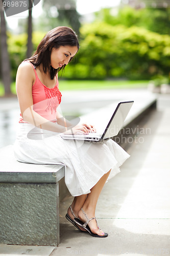 Image of Woman on the phone and working on her laptop
