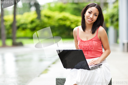 Image of Woman on the phone and working on her laptop