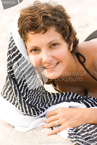 Image of brunet woman lying on a sand