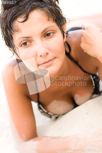 Image of brunet woman lying on a sand