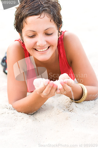 Image of woman in red lying on a sand