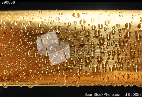 Image of water drops on golden metal