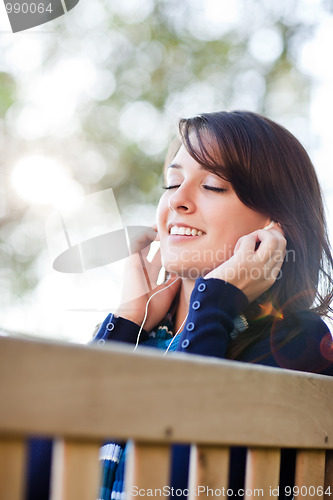 Image of Mixed race ollege student listening to music