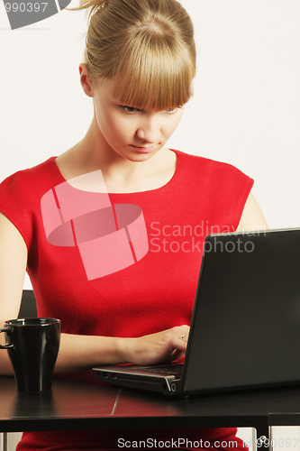 Image of Blonde businesswoman in red typing on laptop