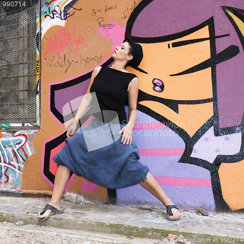 Image of A young woman dancing in front of a wall