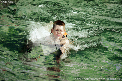 Image of Boy eyes closed swimming with dolphin