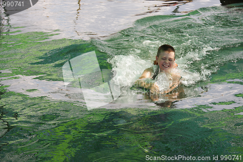 Image of Smiling boy swimming with dolphin