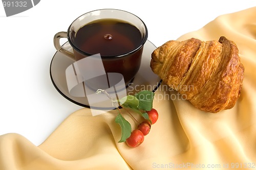 Image of Brown cup of tea and croissants
