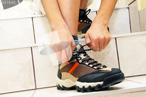 Image of Boy tying his shoe