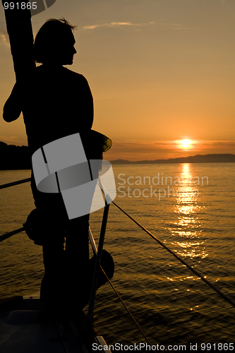 Image of sunset seascape with woman silhouette