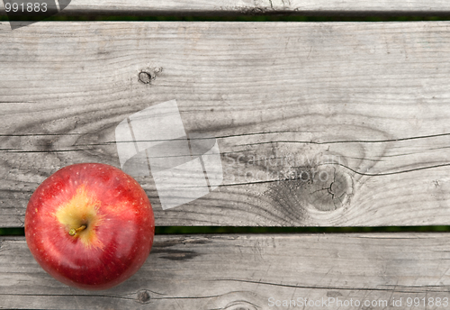 Image of Red apple on old wooden table from above