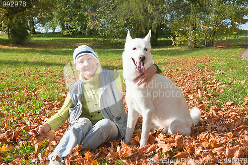 Image of The woman with a white dog in autumn park