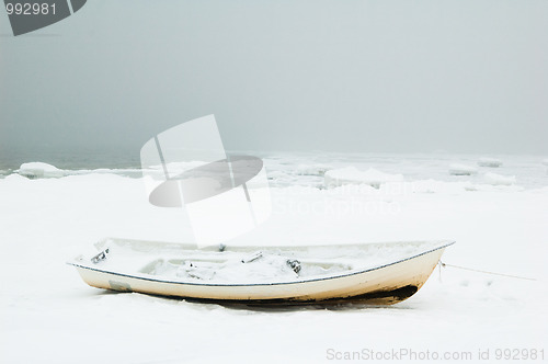Image of Fishing boat on the bank of the frozen sea