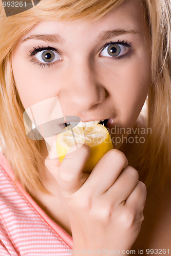 Image of young girl eating lemon