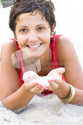 Image of woman in red lying on a sand
