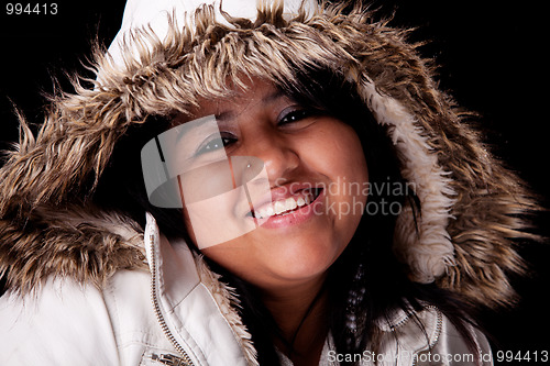Image of Portrait of a young latin woman with a furry hood , in autumn/winter clothes