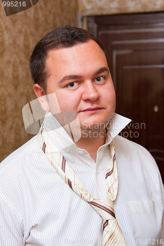 Image of Portrait of a young man wearing shirt with unfastened necktie