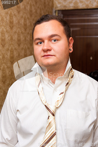 Image of Portrait of a young man wearing shirt with unfastened necktie