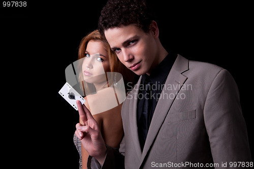 Image of young couple, man holding a ace of spades