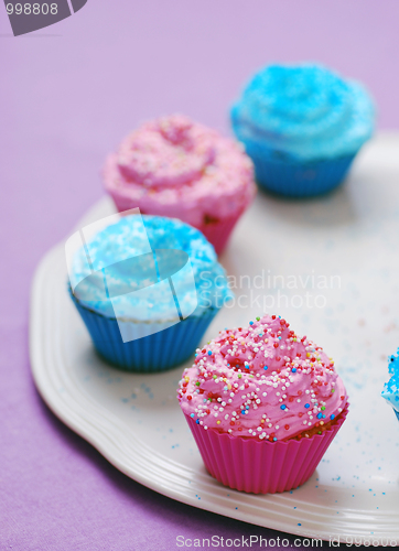 Image of freshly baked pink and blue cupcakes 