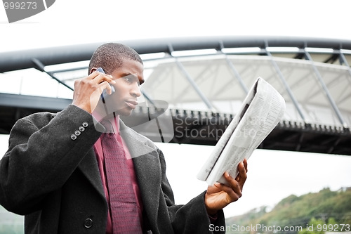 Image of Businessman reading newspaper