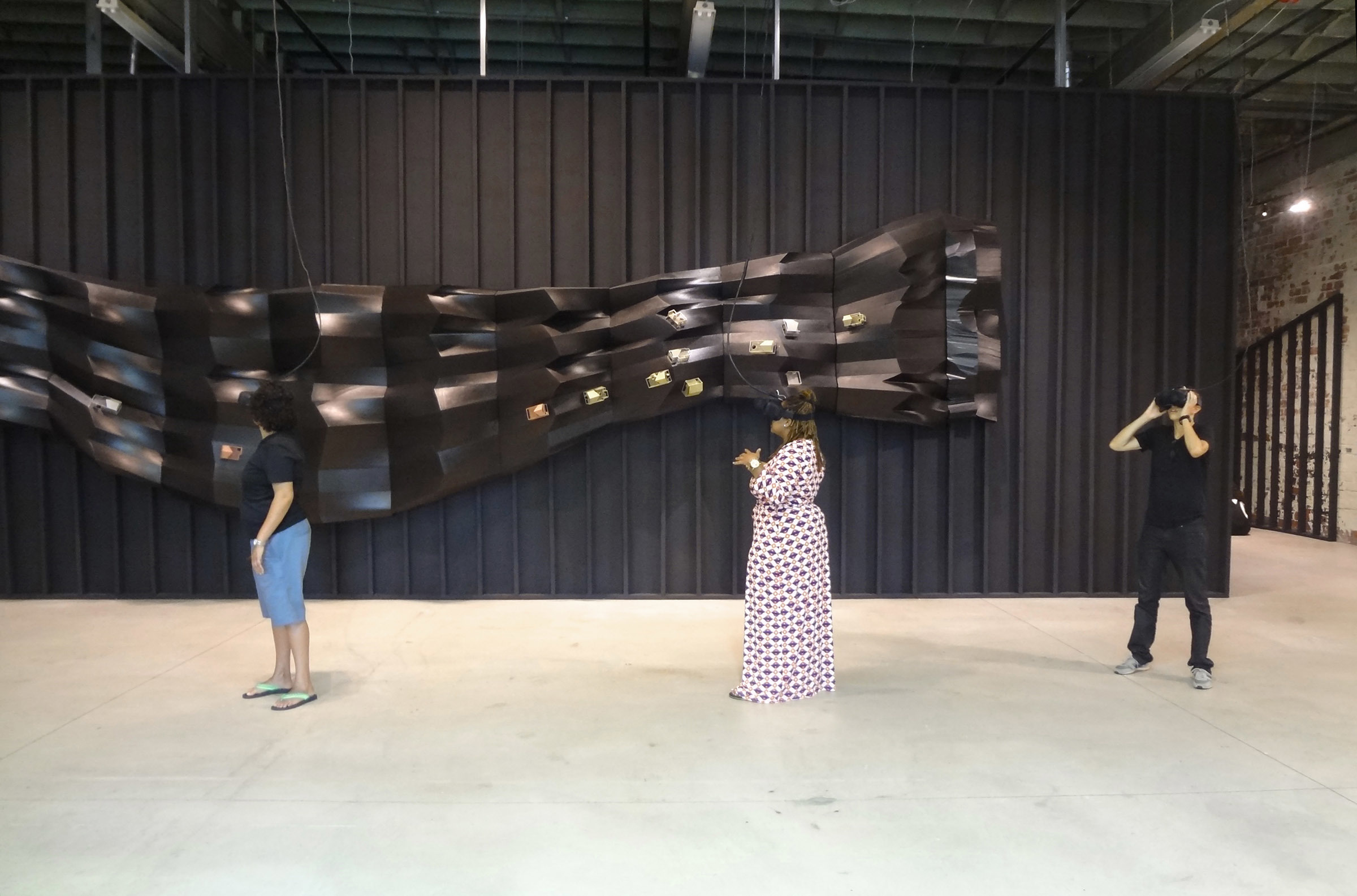 people experiencing AR within black corrugated gallery space