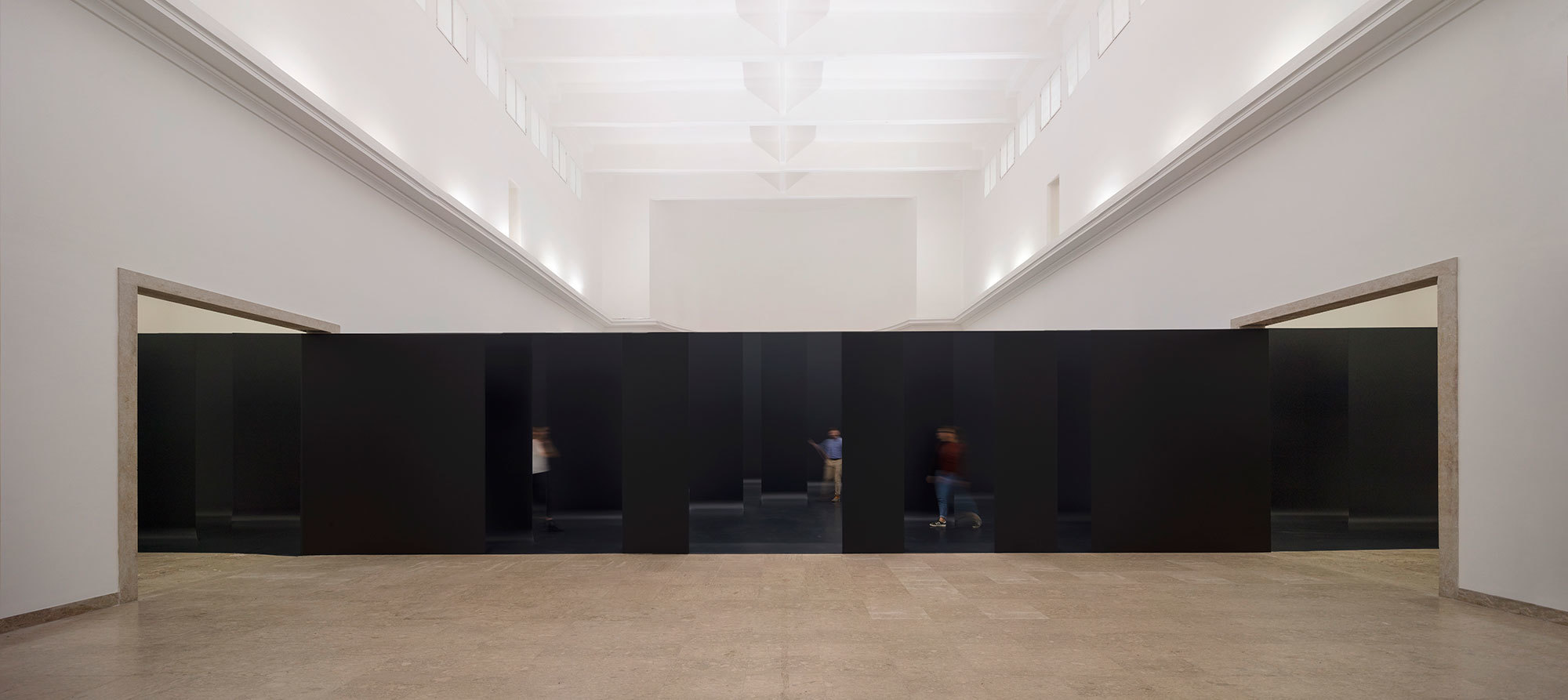 long black pavilion within multiple gallery spaces