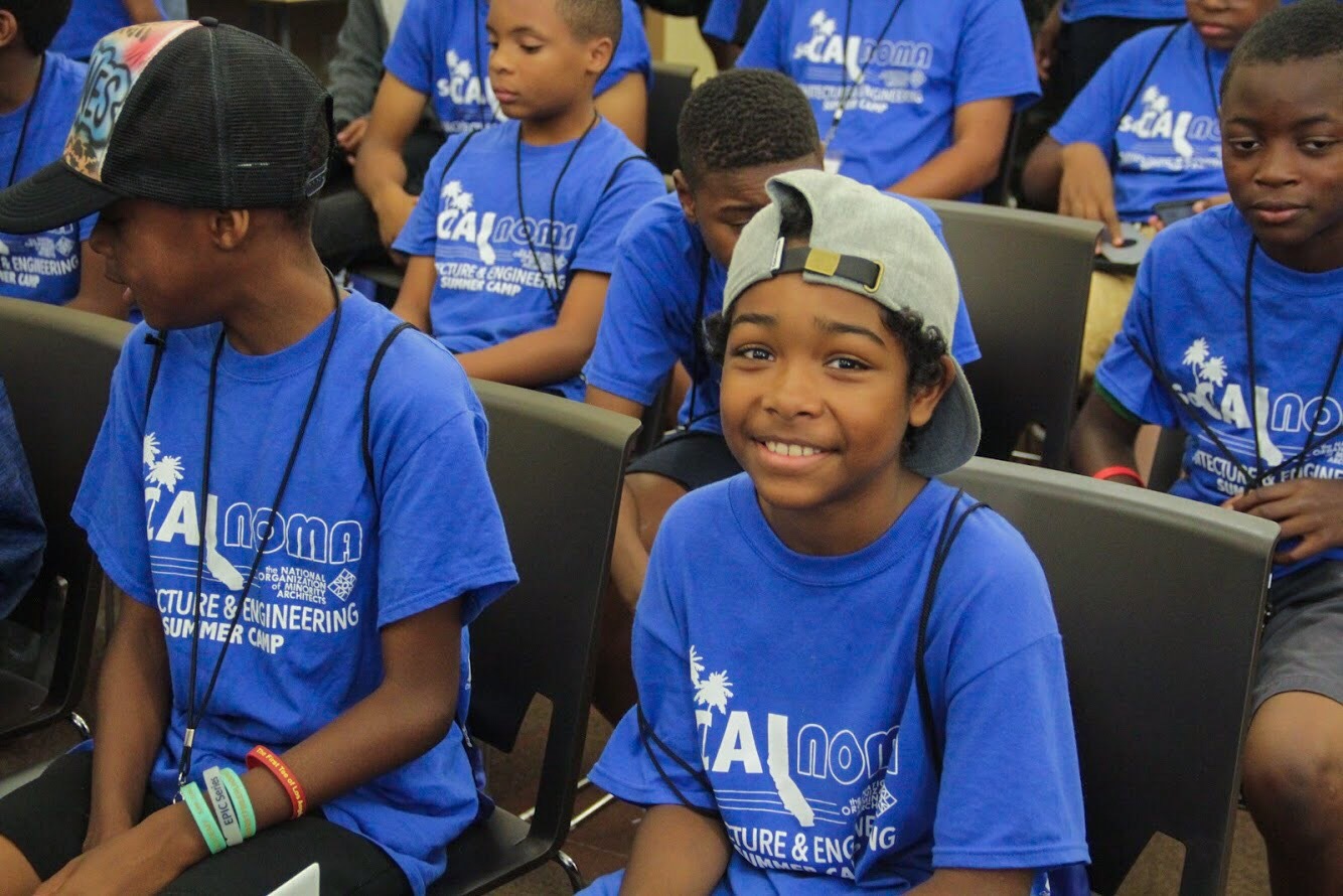 group of seated happy children in blue shirts