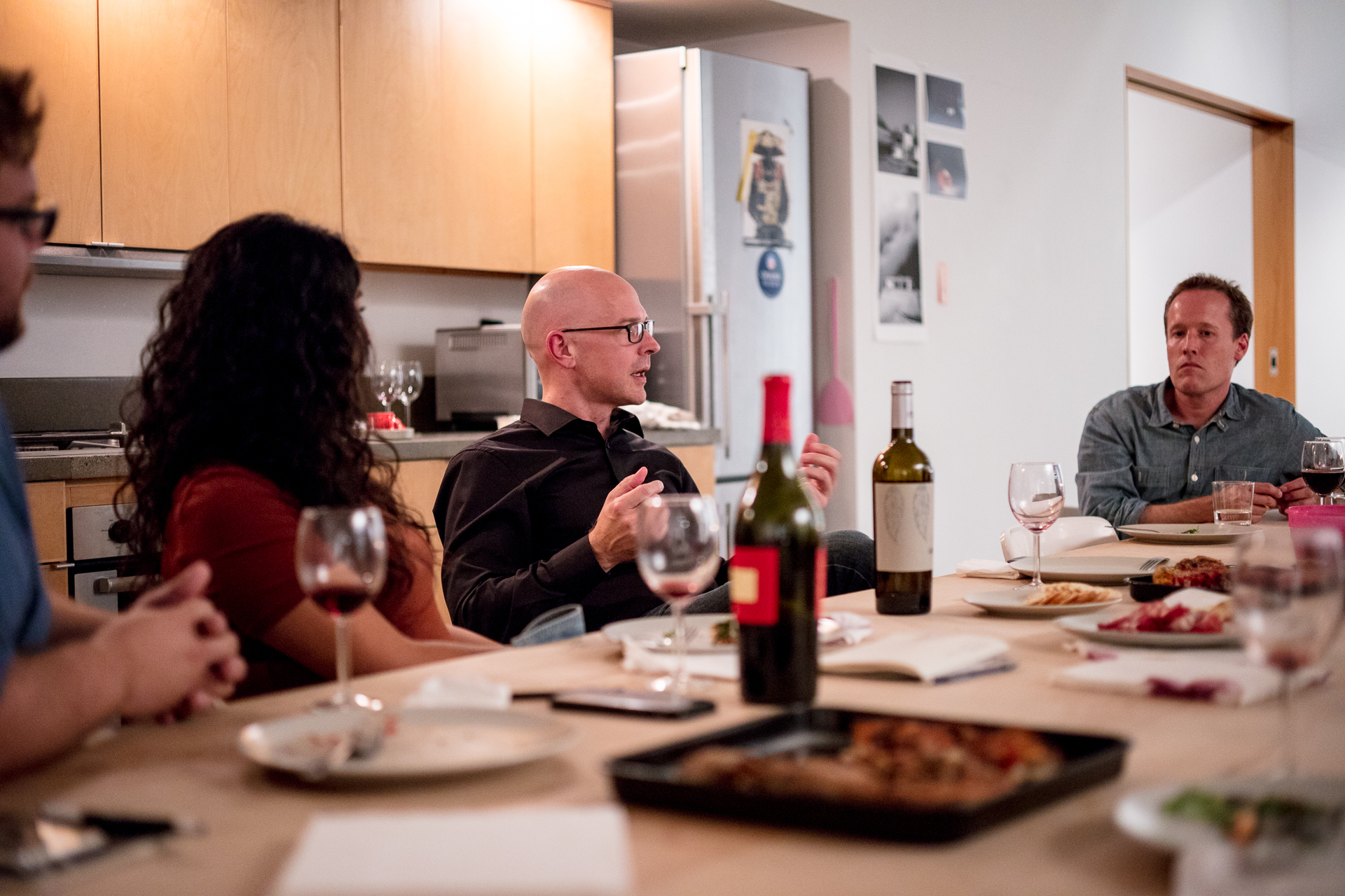 attentive people listening to friend at dinner setting