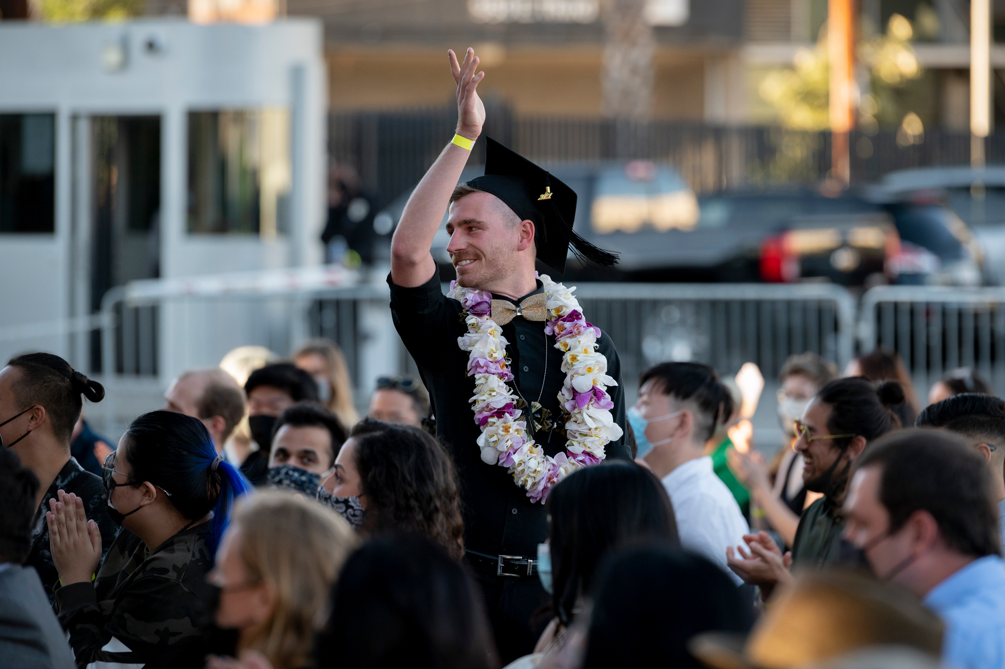 man celebrating graduation cap crowd