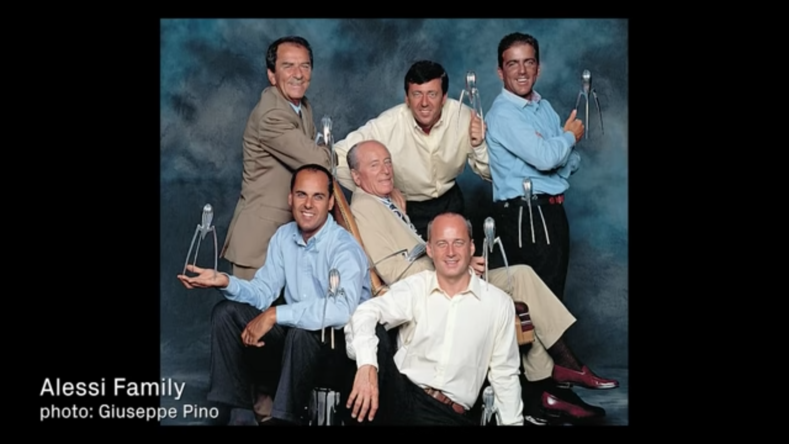 group of men smiling holding sculptures