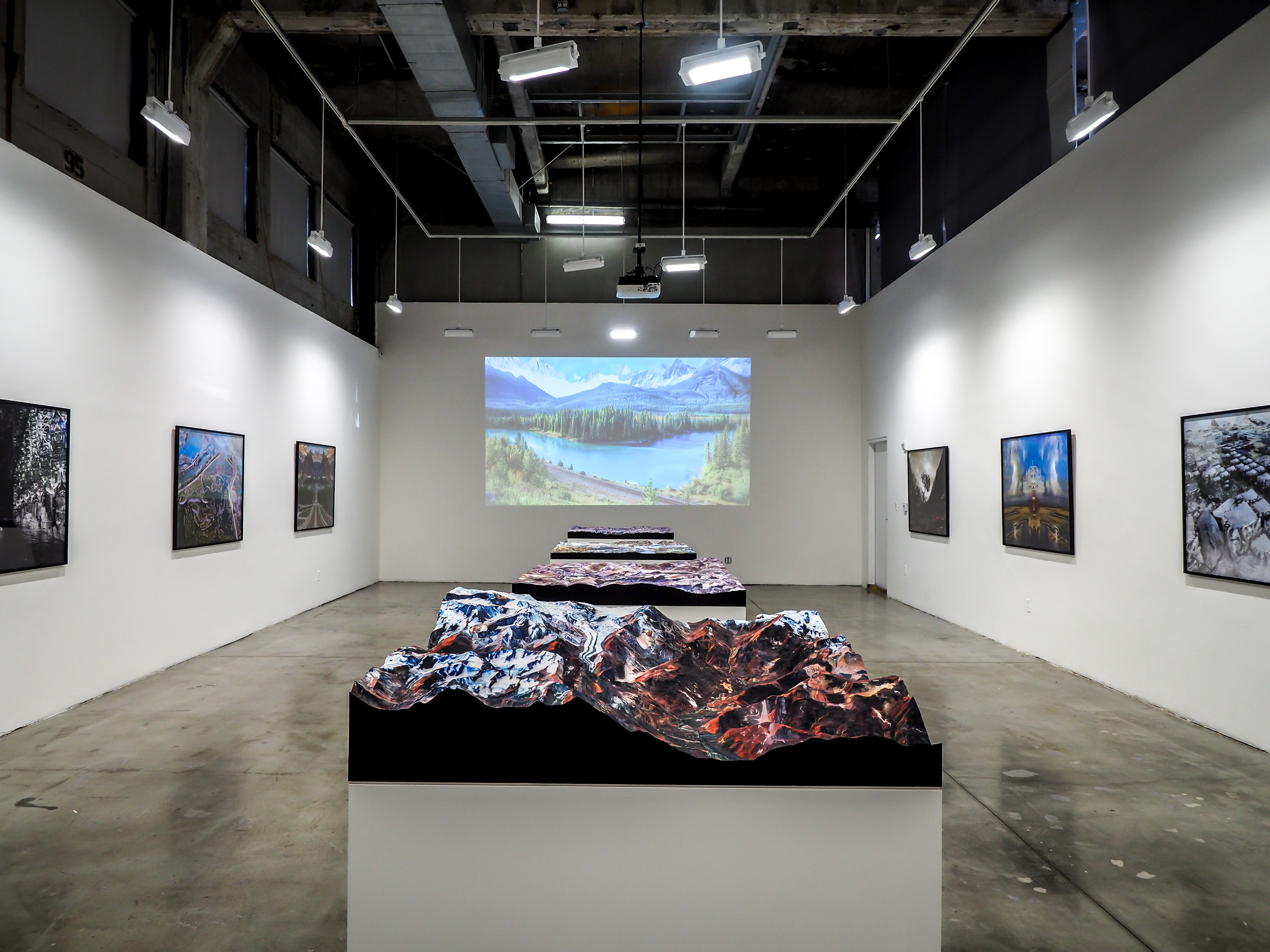 Terrain models exhibited in the center of Gallery space with images on wall