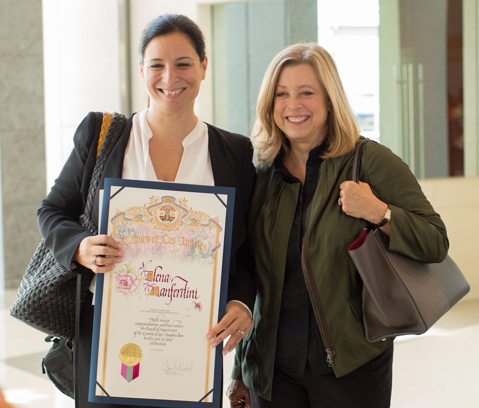 Elena Manferdini receiving a certificate from county of Los Angeles