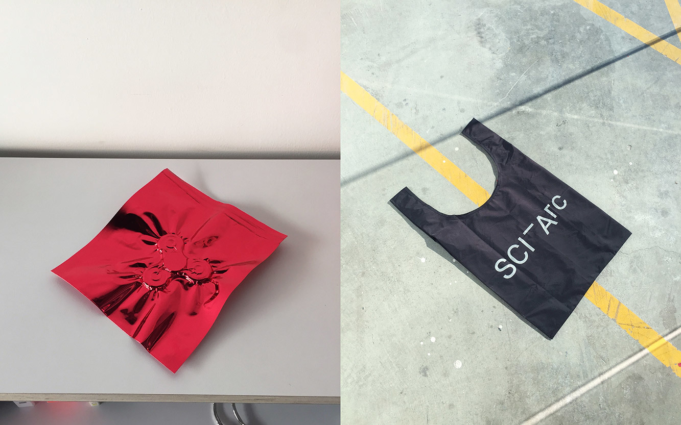 SCI-Arc fidget Spinner in Red cover and a black SCI-Arc bag on concrete floor