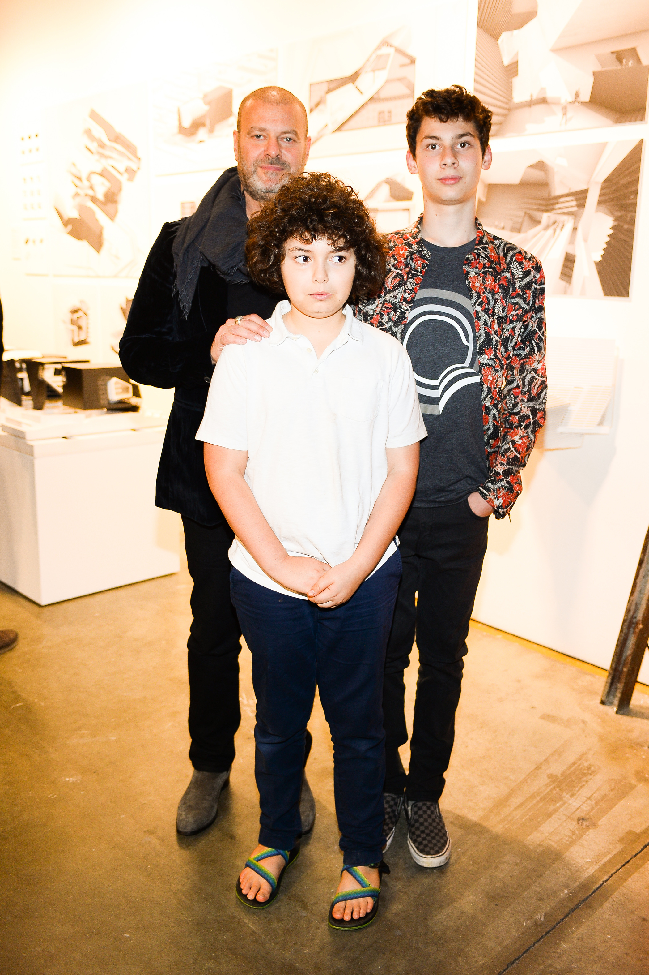 A man and two boys stand and pose for a photo together.