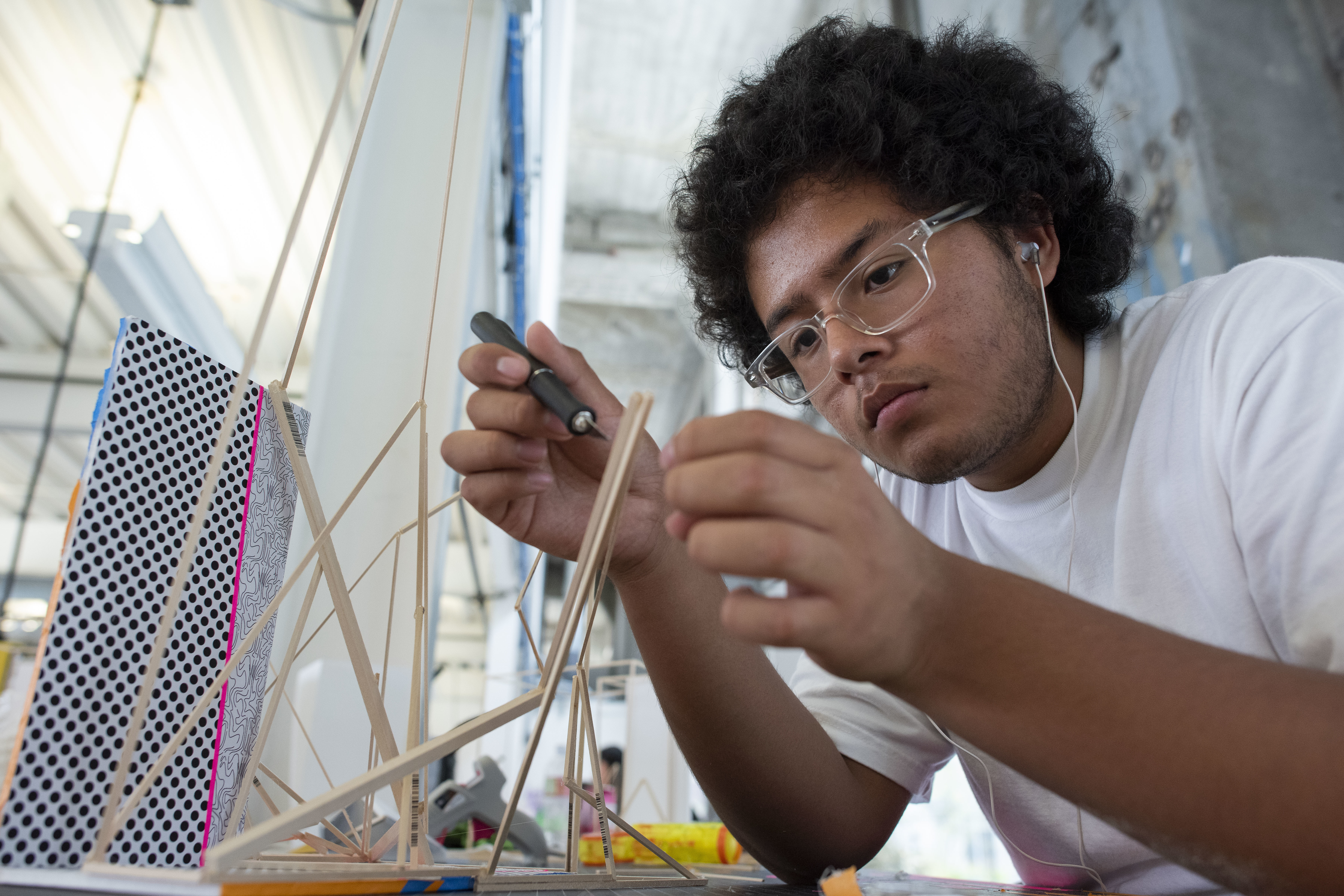 High school kid fabricating architectural model during the summer workshop