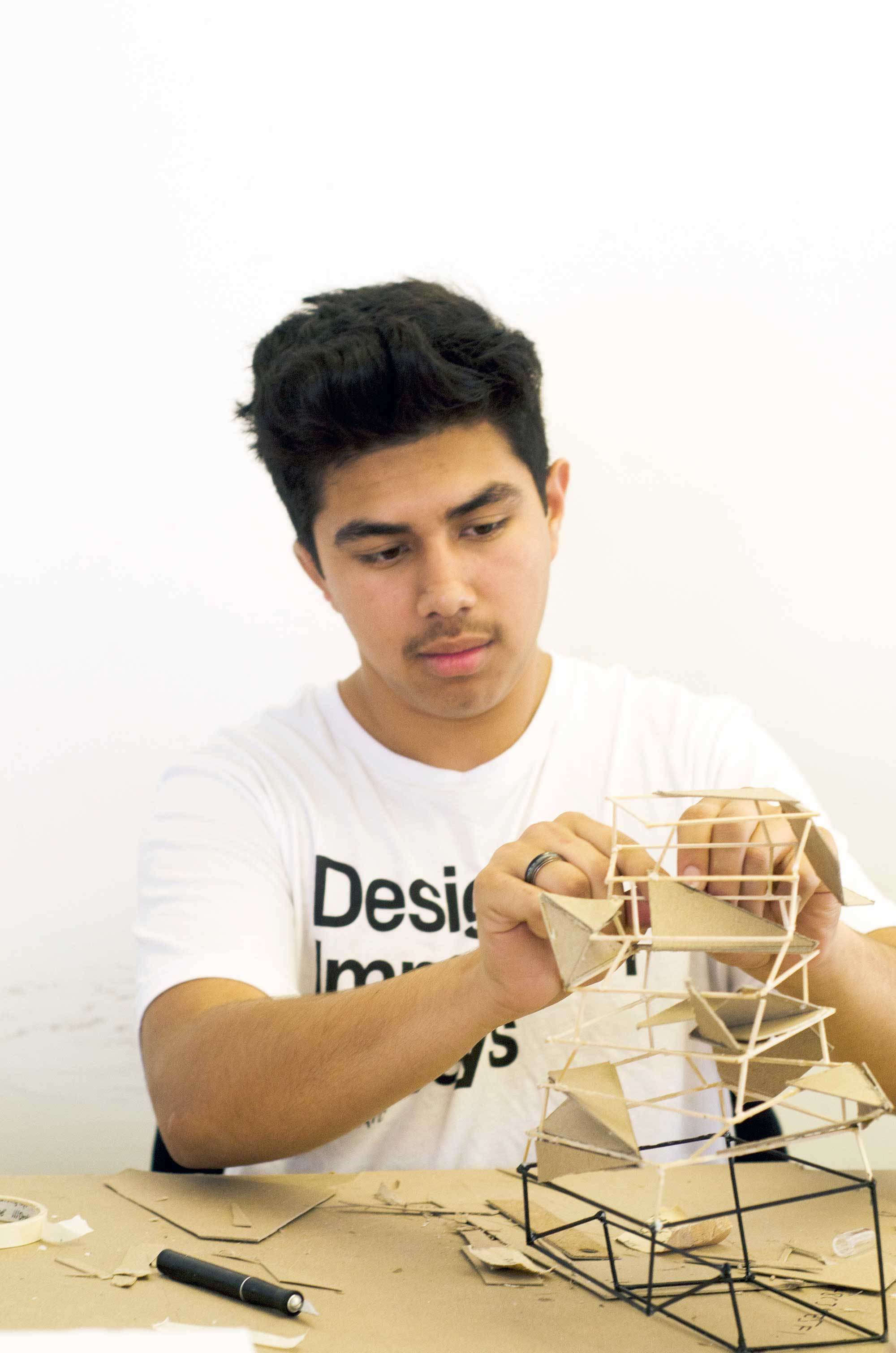 High school boy fabricating architectural model during the summer workshop