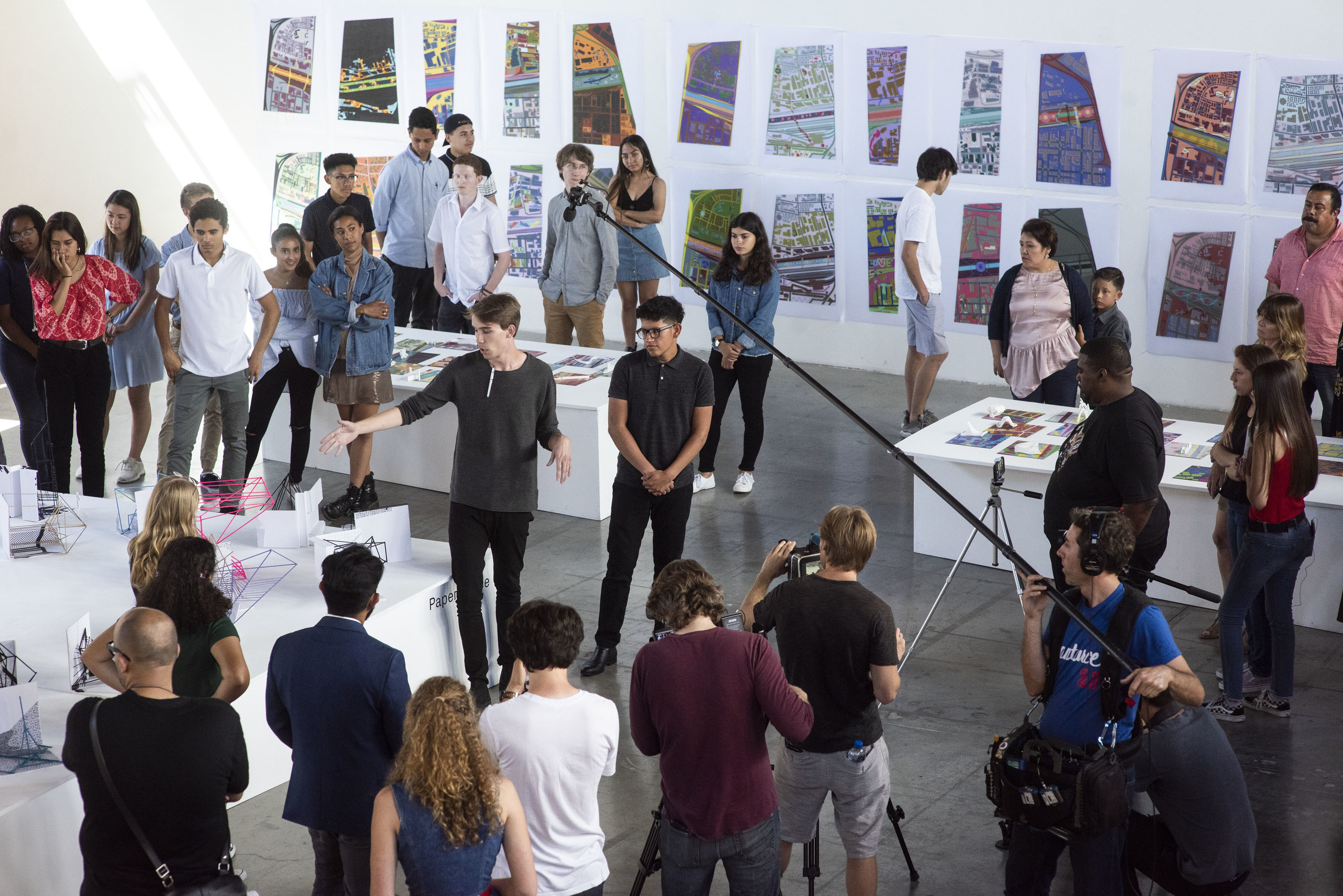 two participants being filmed while presenting their project