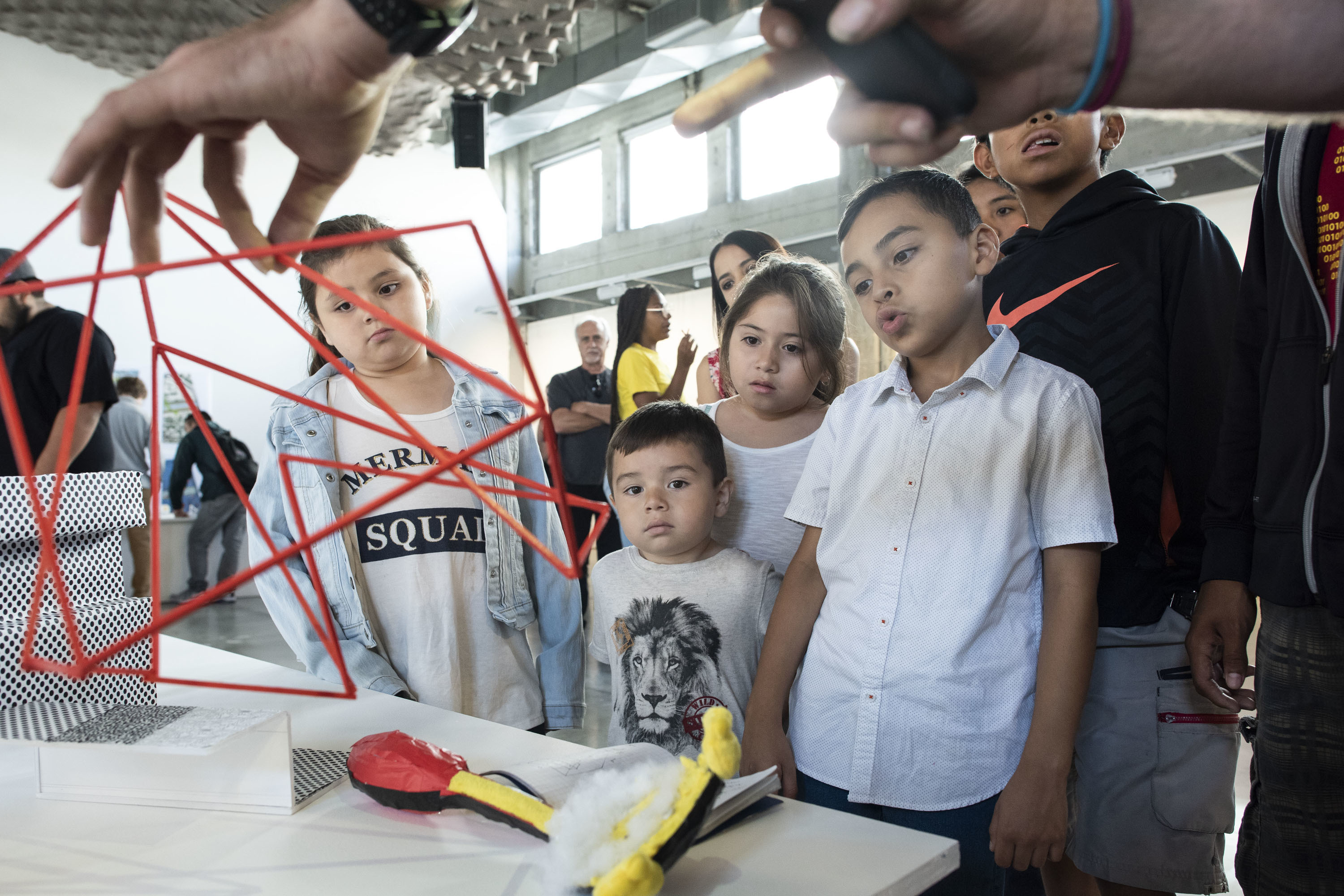 A workshop participant presenting their project to a bunch of children