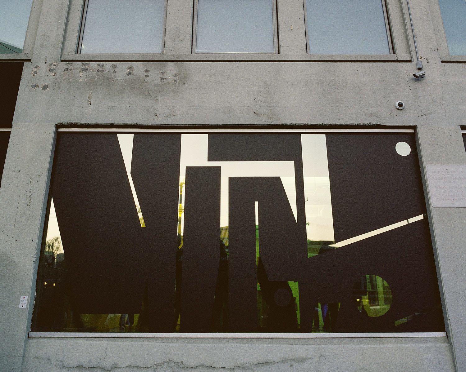 concrete building with a big window and black graphic decal