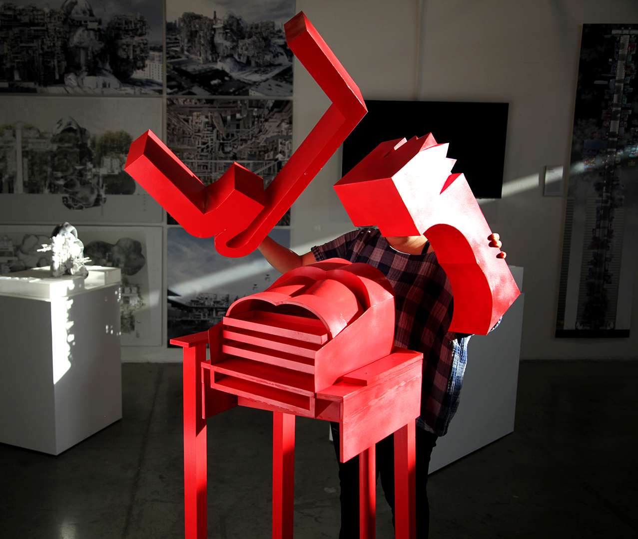 SCI Arc student assembling a red architectural model