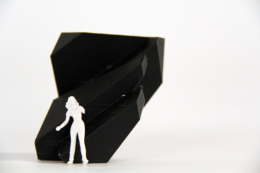 black slanted Architectural Model whit a white human model standing in front