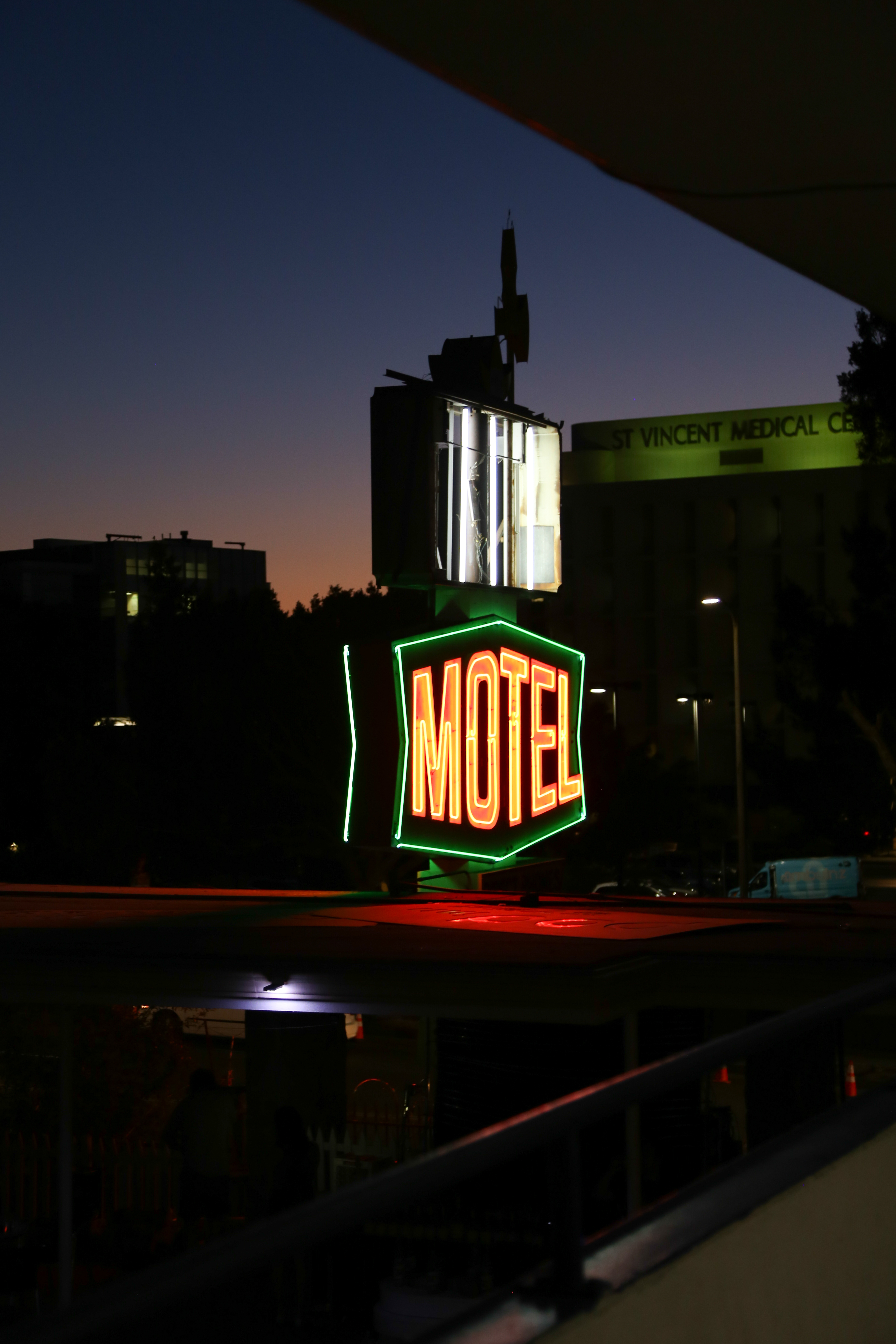 a neon light symbol with green borders and yellow text reading Motel