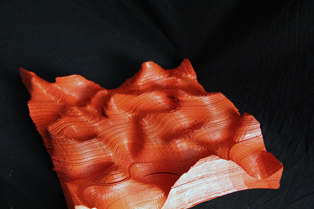 a orange 3D printed model of landscape dunes