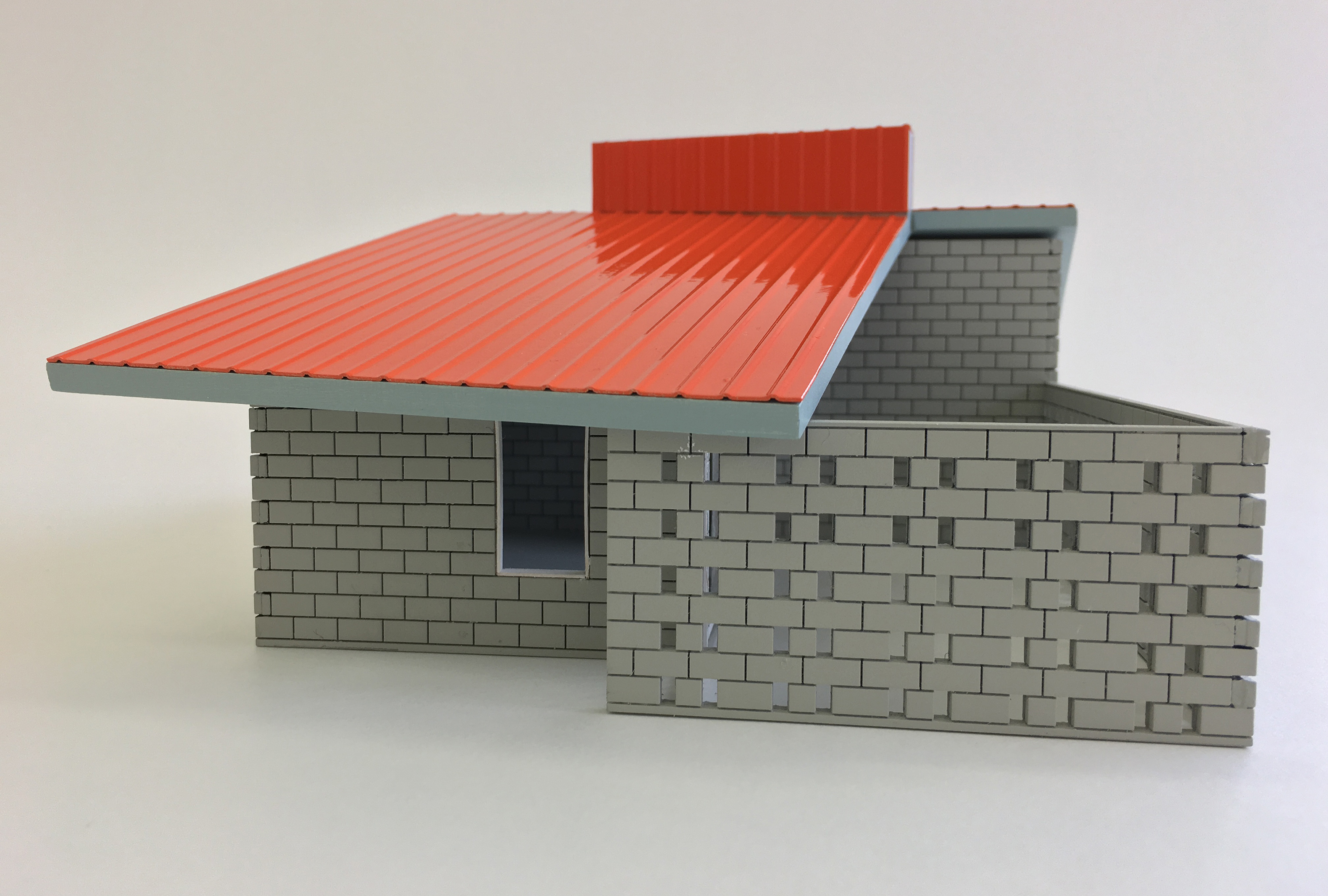 Architectural model of house with grey bricks and orange roof