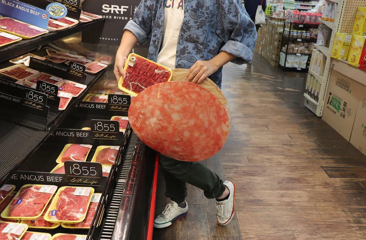 Supermarket photograph photo with person holding case / briefcase with salami graphic