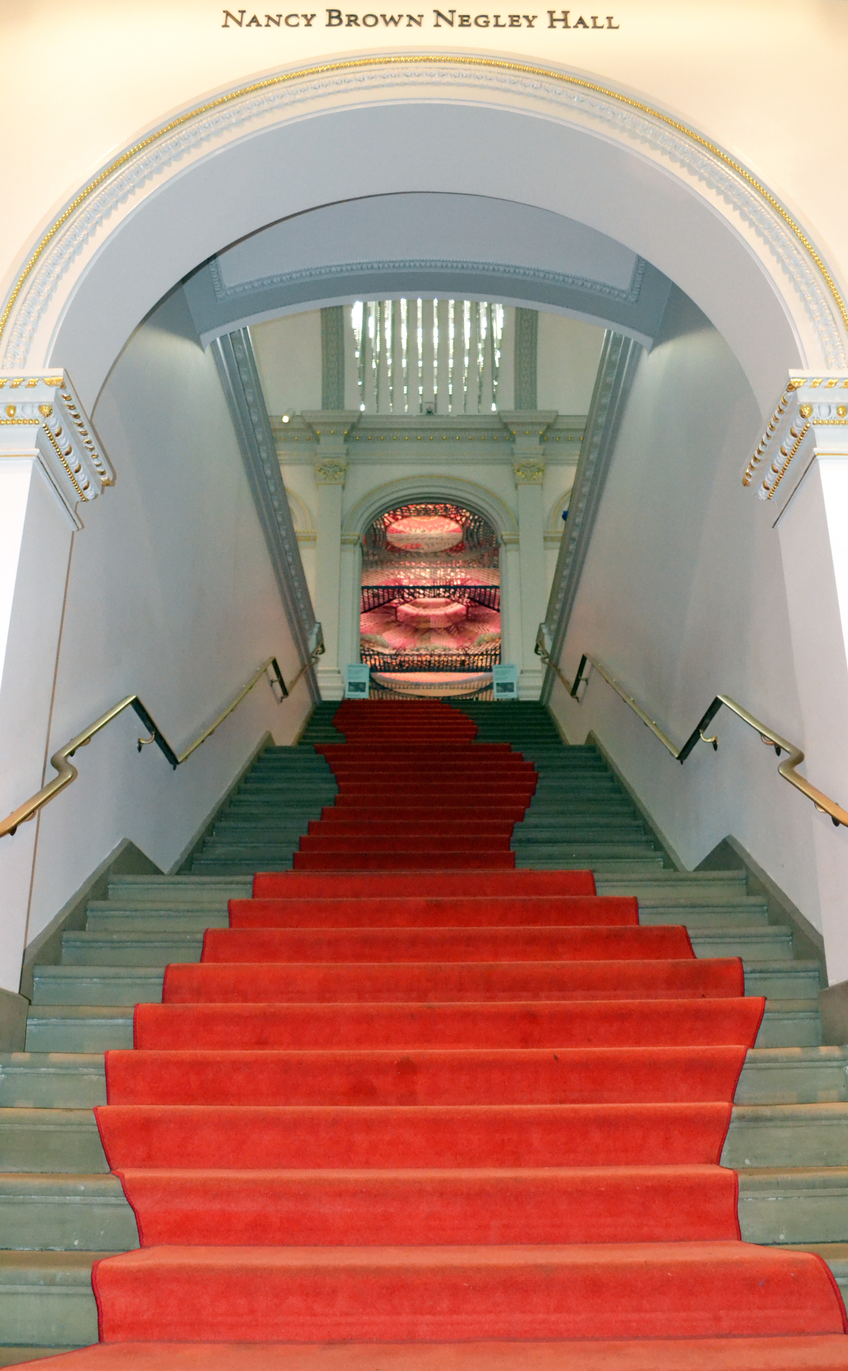 undulating red carpet up stairway into grand room