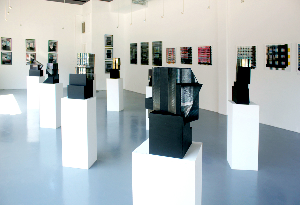 stacked cubic black architectural models on podium in gallery