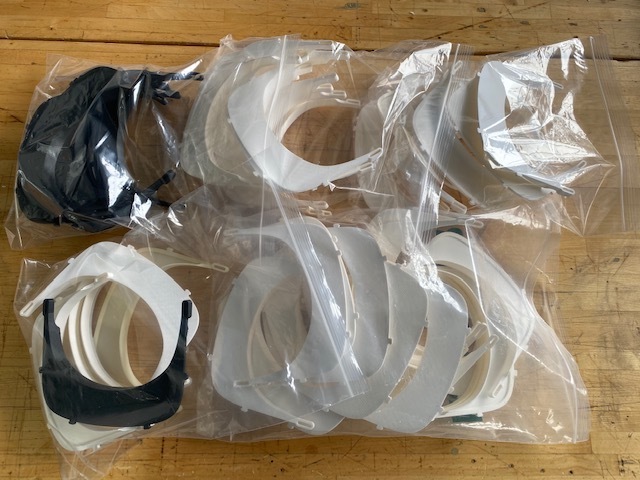 Face shield harnesses are immediately removed from 3D printers and bagged, for sanitary purposes.