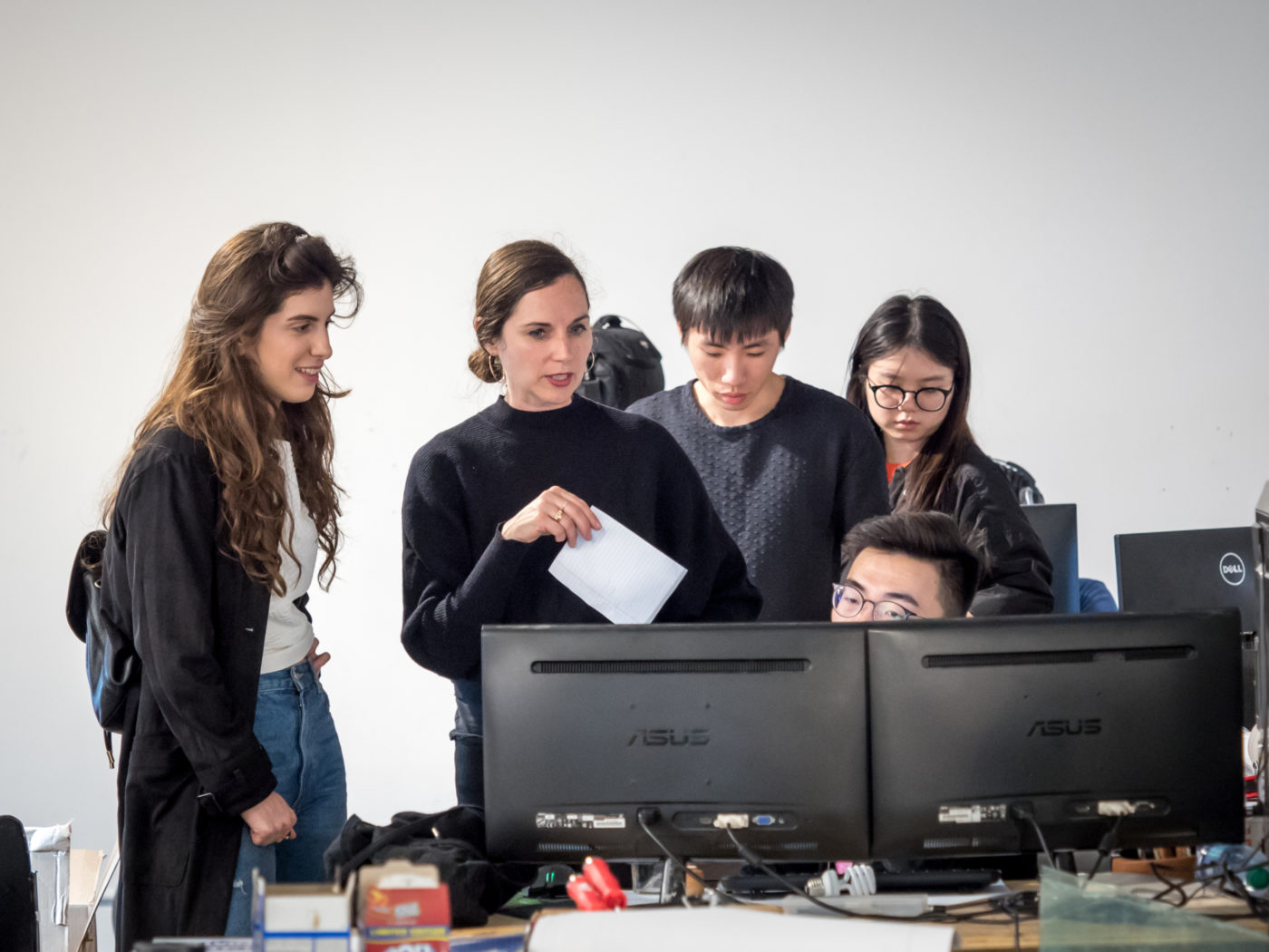 Group of students around computer discussing with florencia pita in architecture school
